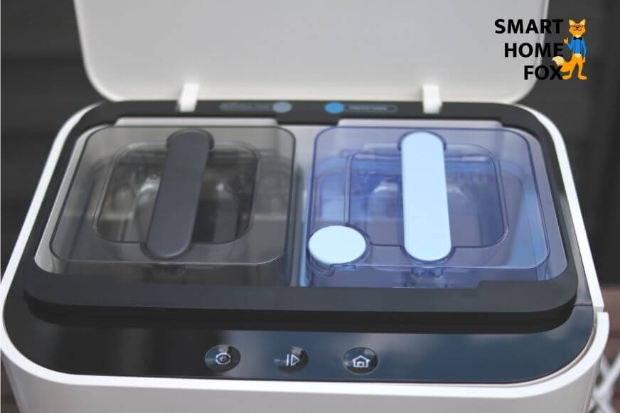 Die Yeedi Mop Station steht mit offener Klappe auf dem Boden, sodass die beiden Wassertanks zu sehen sind